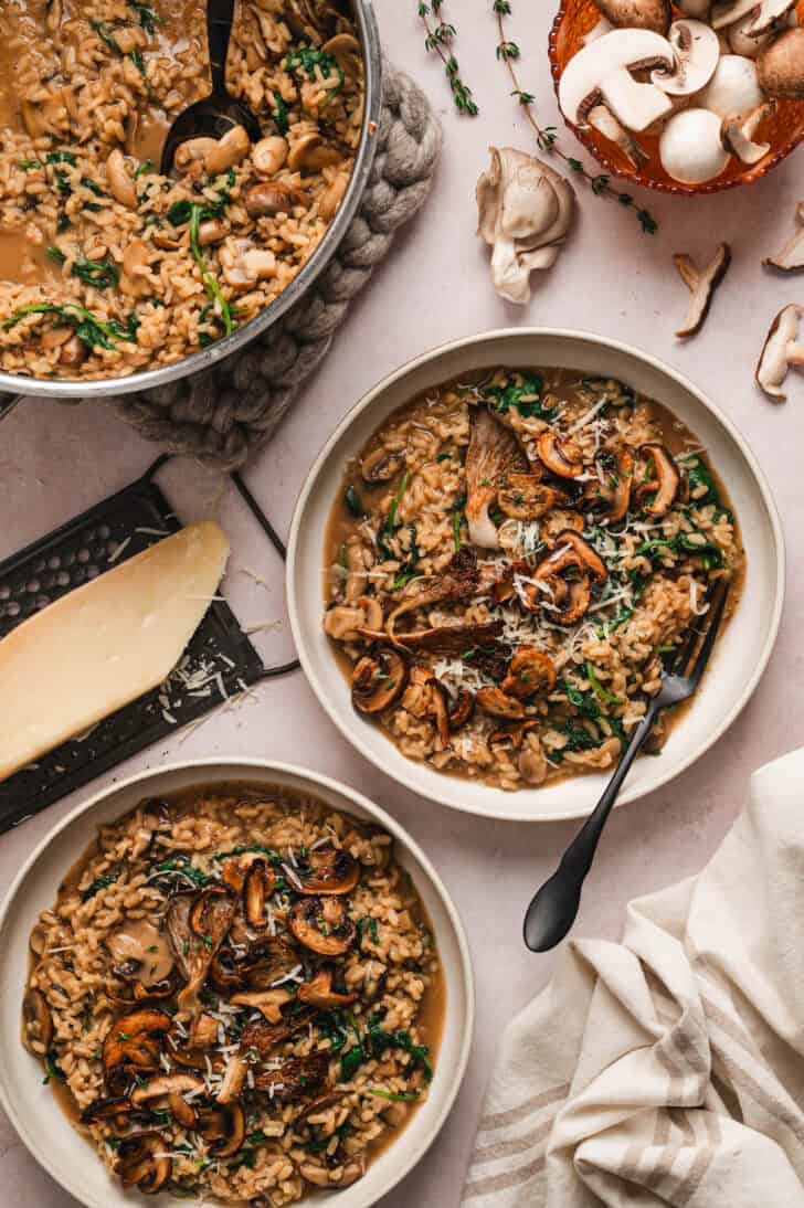 A dinner scene with bowls of mushroom kale risotto.