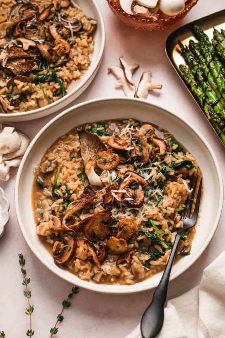 The best mushroom risotto recipe, in a bowl with a black fork.