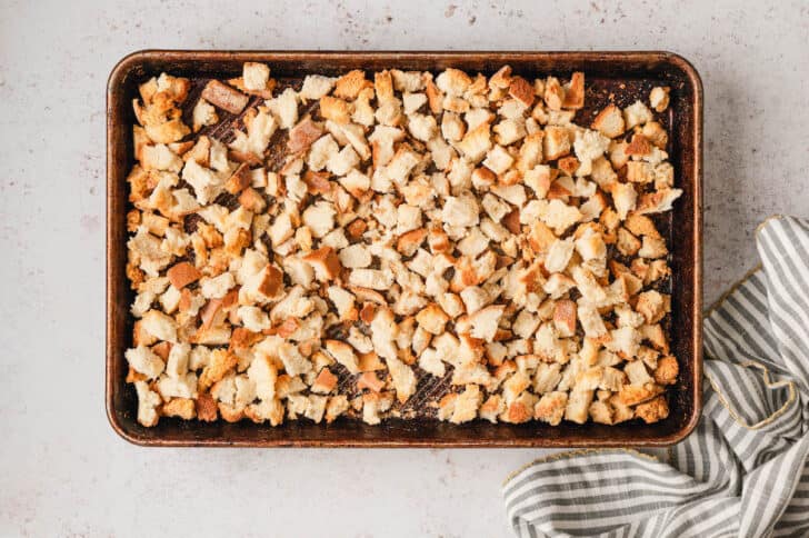 Torn bread cubes on a baking pan.