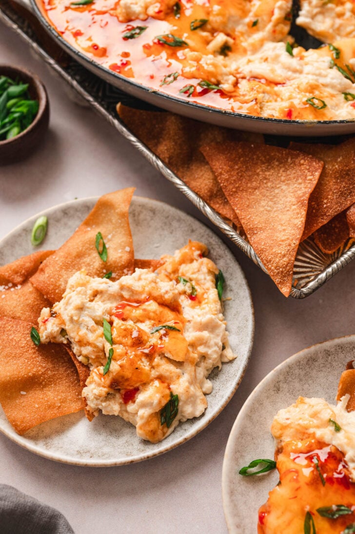 Hot crab rangoon dip on a plate with wonton chips.