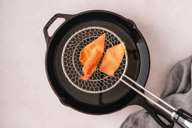 Wonton chips being fried in oil.