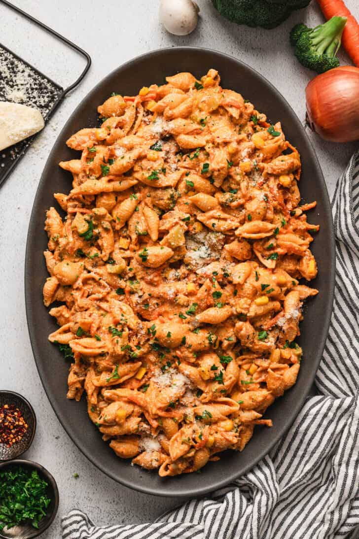 A large gray oval platter filled with vegetable pasta.