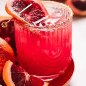 A blood orange margarita garnished with a slice of blood orange.