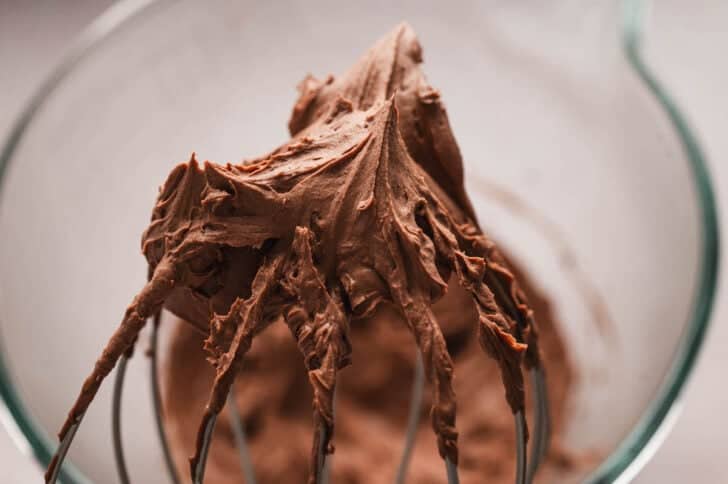 A whisk showing a closeup shot of easy chocolate mousse after it has been whipped.