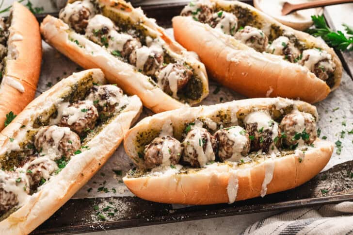 A meatball subs recipe on a rimmed baking pan.