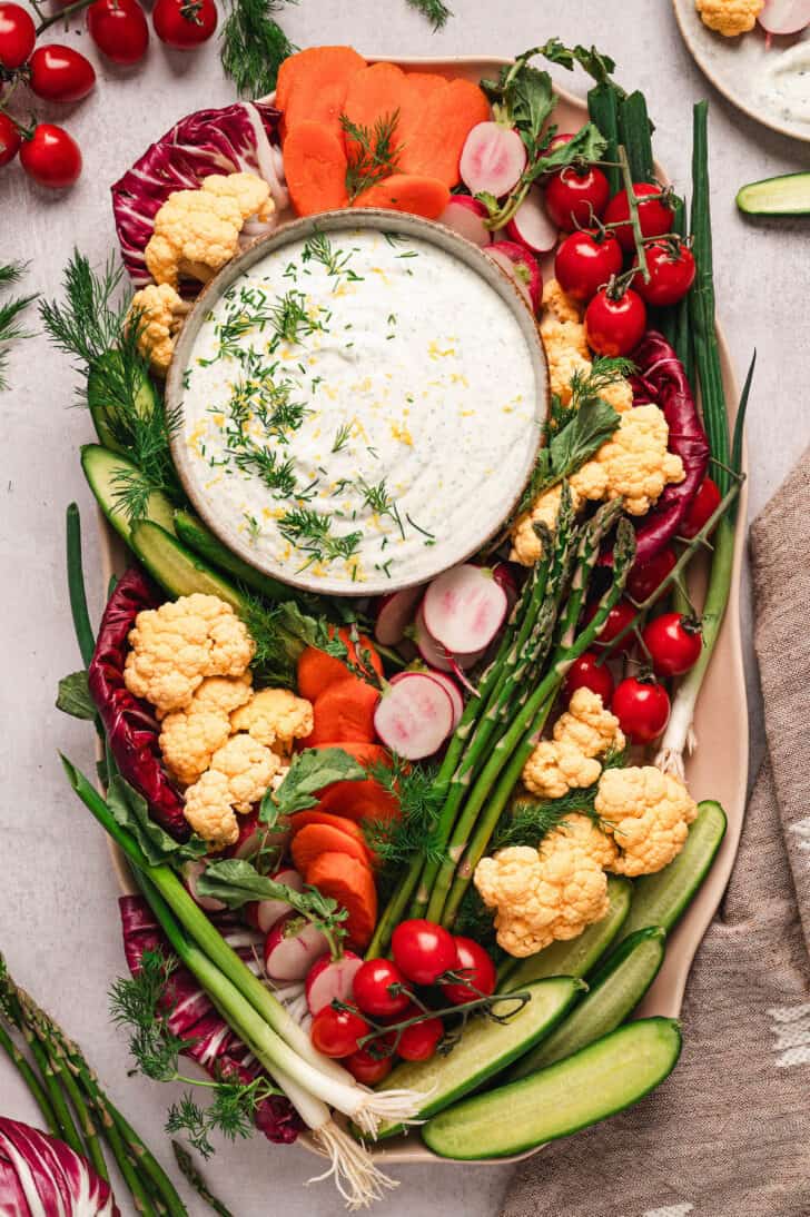 A tray of dill veggie dip and fresh cut vegetables.