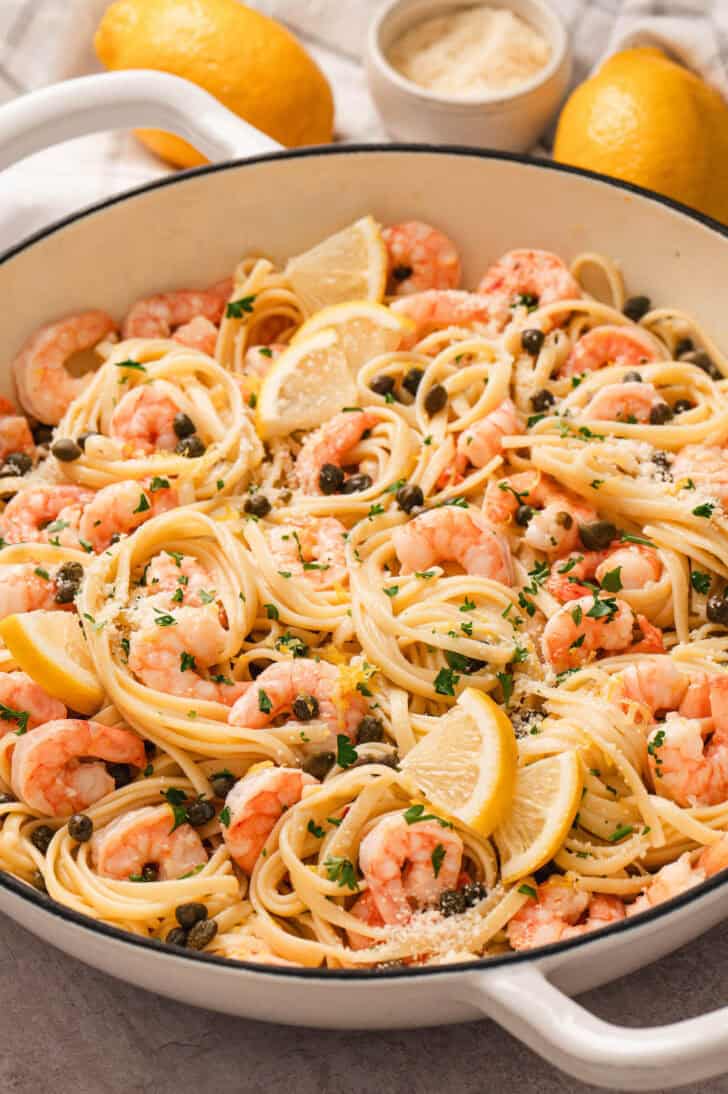 A white skillet filled with a lemon shrimp pasta recipe.