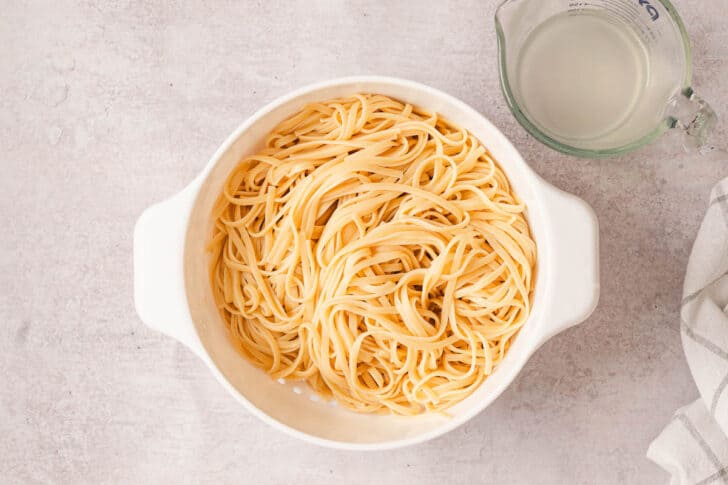 A white colander filled with cooked linguine.