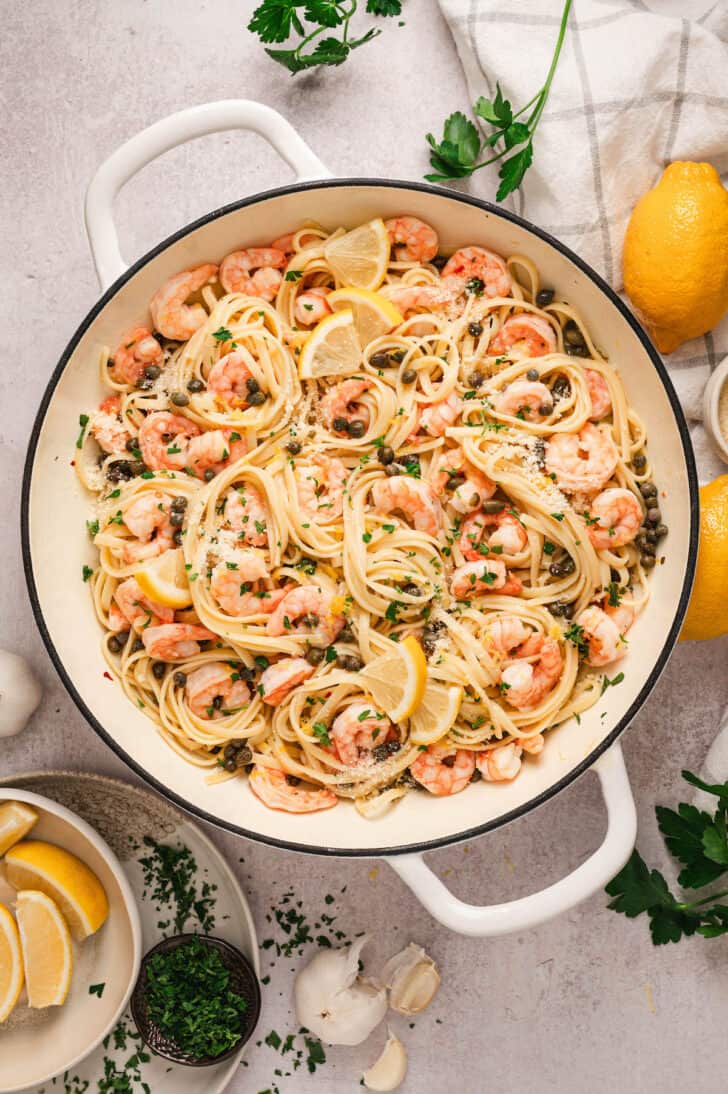 A white skillet filled with lemon caper shrimp pasta.