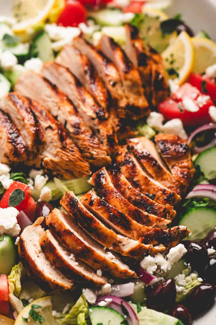 Grilled chicken marinated in a Greek chicken marinade recipe sliced and served over a salad.