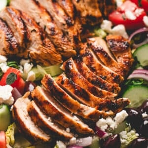 Grilled chicken marinated in a Greek chicken marinade recipe sliced and served over a salad.