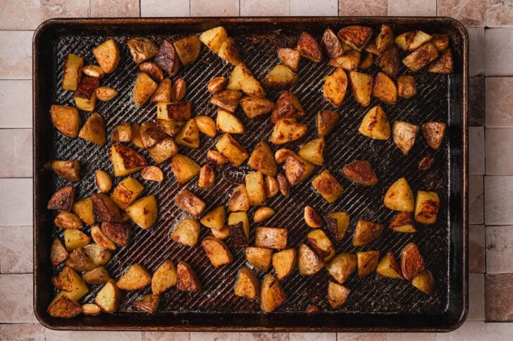 A rimmed baking pan with a breakfast potato recipe on it.