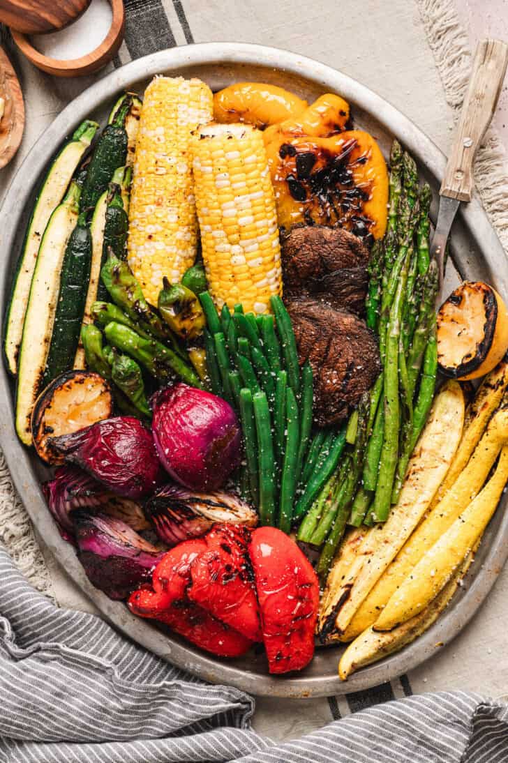 A big platter of the best vegetables to grill, including beans, asparagus, corn, bell peppers, squash, mushrooms, corn and onion.