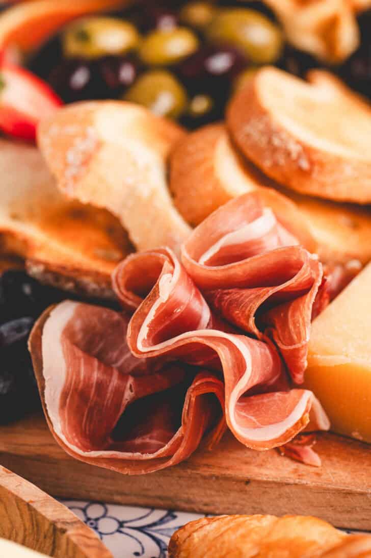 A ruffle of prosciutto on a cutting board.