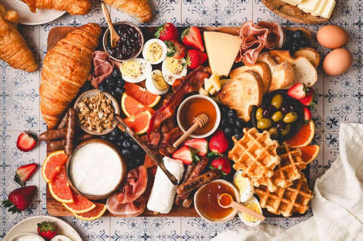 A breakfast board on a tiled surface.