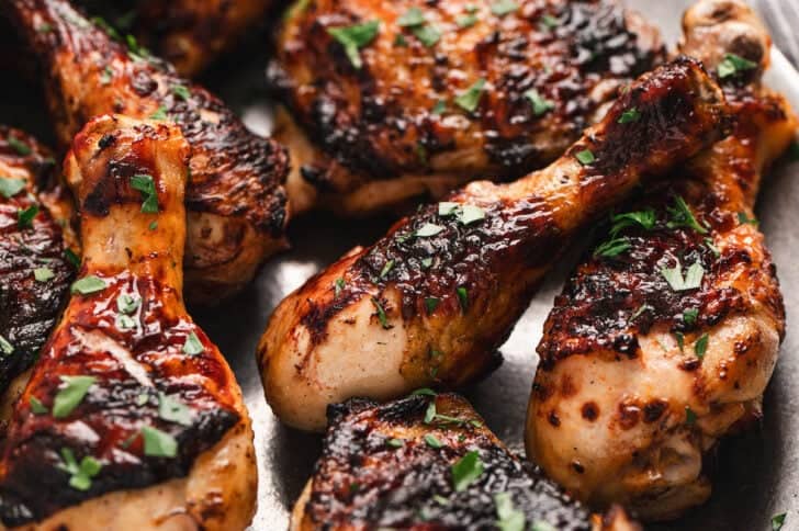 Grilled poultry pieces on a platter.