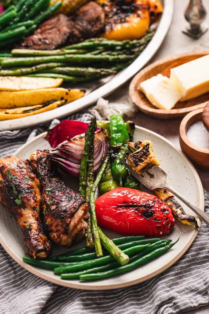 A dinner plate with grilled chicken and vegetables.