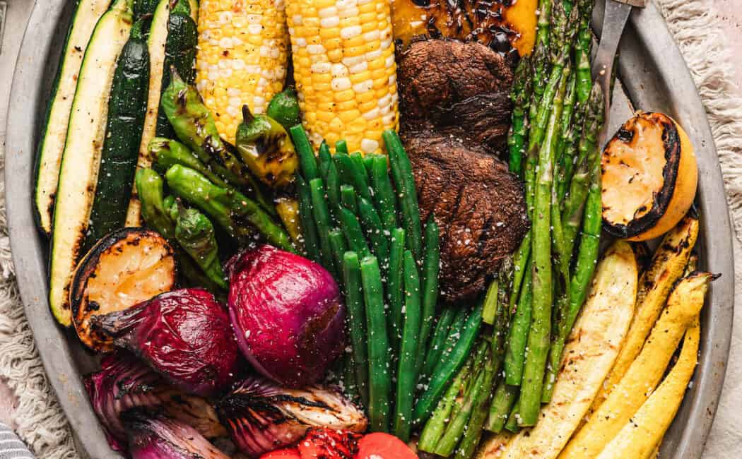 A big platter of the best vegetables to grill, including beans, asparagus, corn, bell peppers, squash, mushrooms, corn and onion.