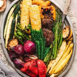 A big platter of the best vegetables to grill, including beans, asparagus, corn, bell peppers, squash, mushrooms, corn and onion.