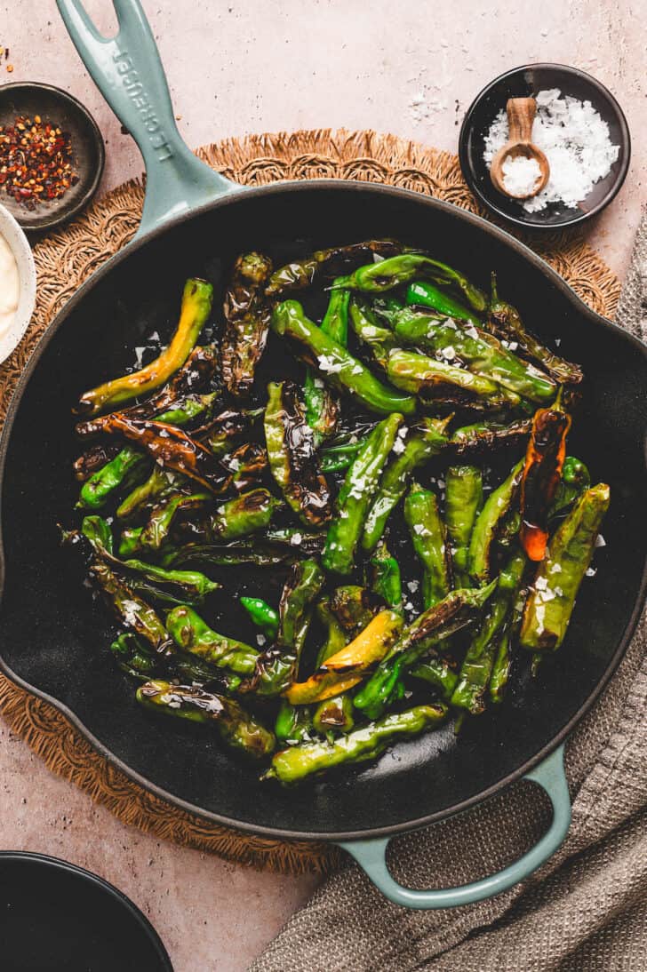 A skillet serving a blistered shishito pepper recipe.