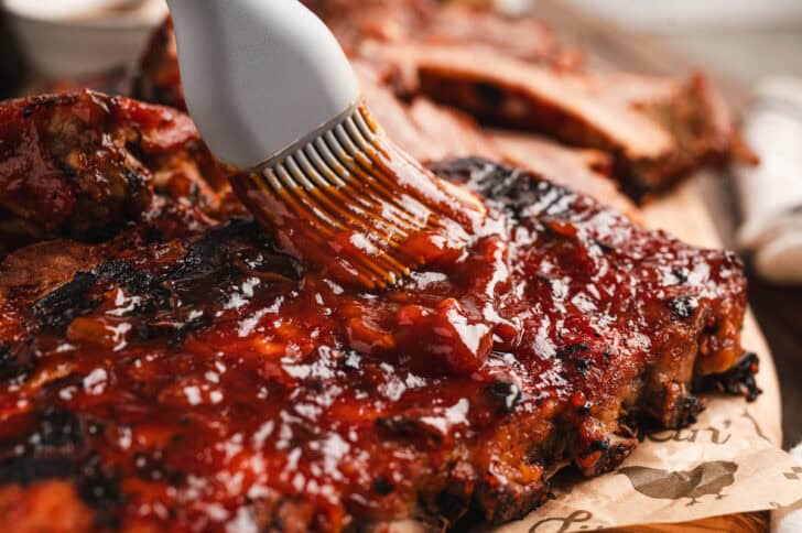 A silicone brush basting root beer ribs with sauce.