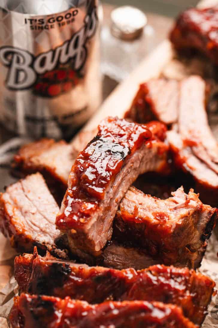Sliced baby back ribs that have been made with a pork rib marinade, with a Barqs root beer in the background.