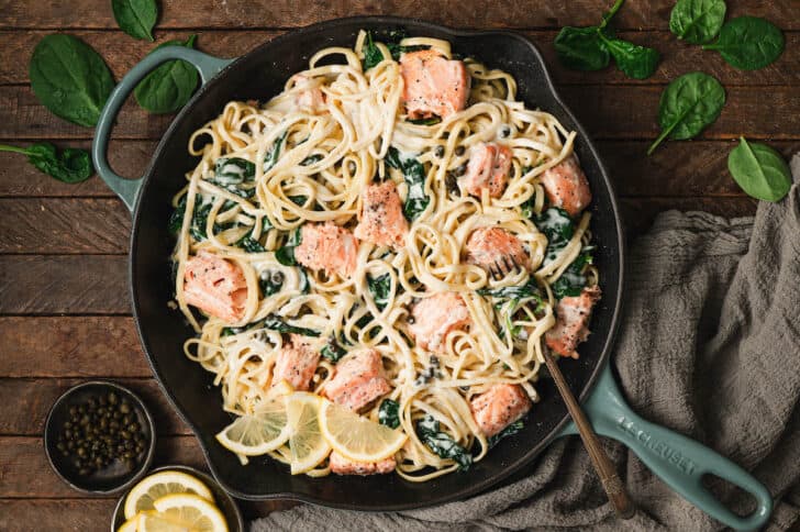 A cast iron skillet filled with salmon pasta.