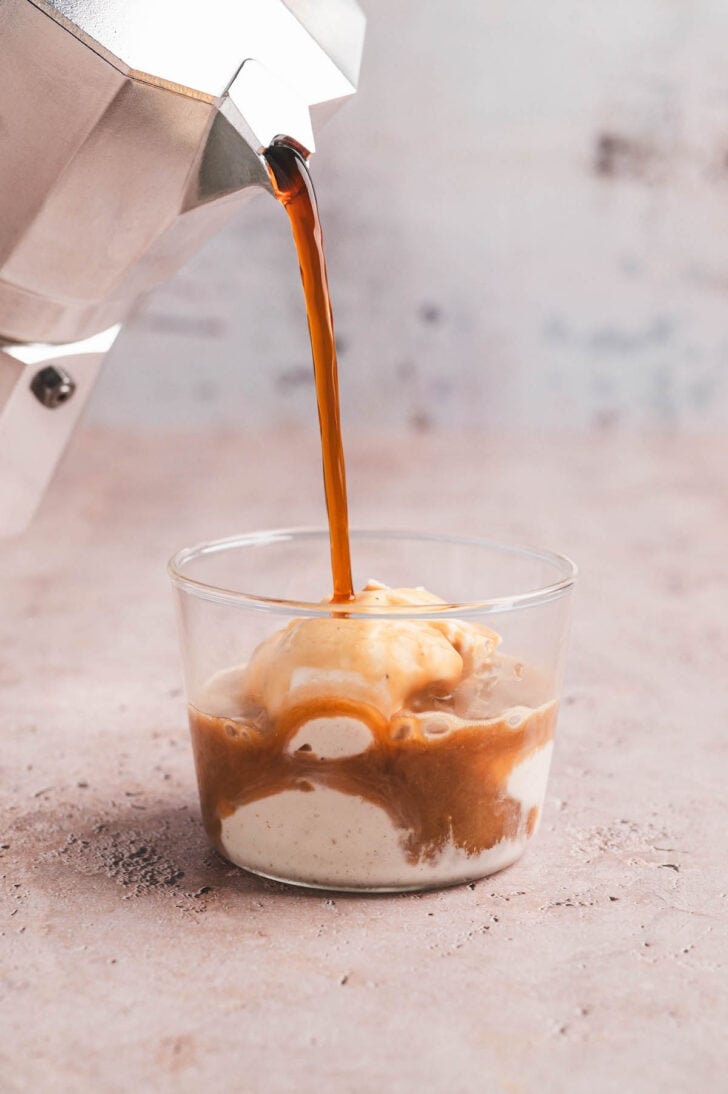 Espresso being poured over ice cream to make affogato coffee.