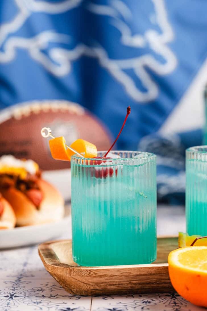 Blue cocktail drinks in front of a Detroit lions flag.
