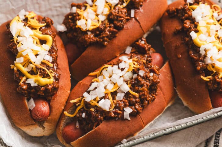 Four servings of a chili dog chili recipe served over hot dogs.