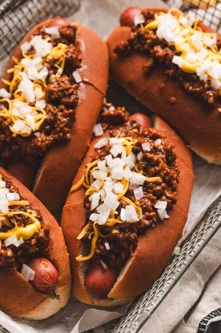 Four hot dogs covered in a recipe for hot dog chili.