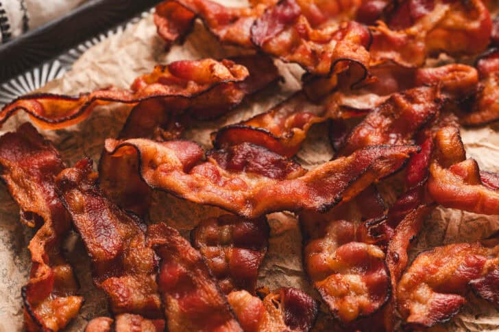 Air fried bacon strips on parchment paper.