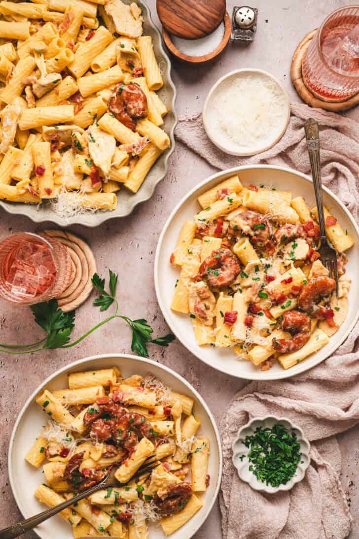 A dinner scene with plates of chicken and shrimp carbonara.