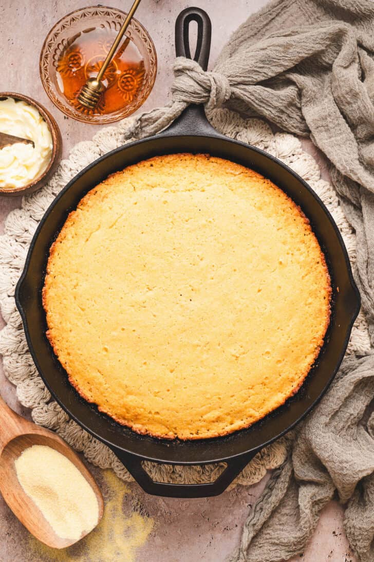 A cast iron skillet filled with honey butter cornbread.