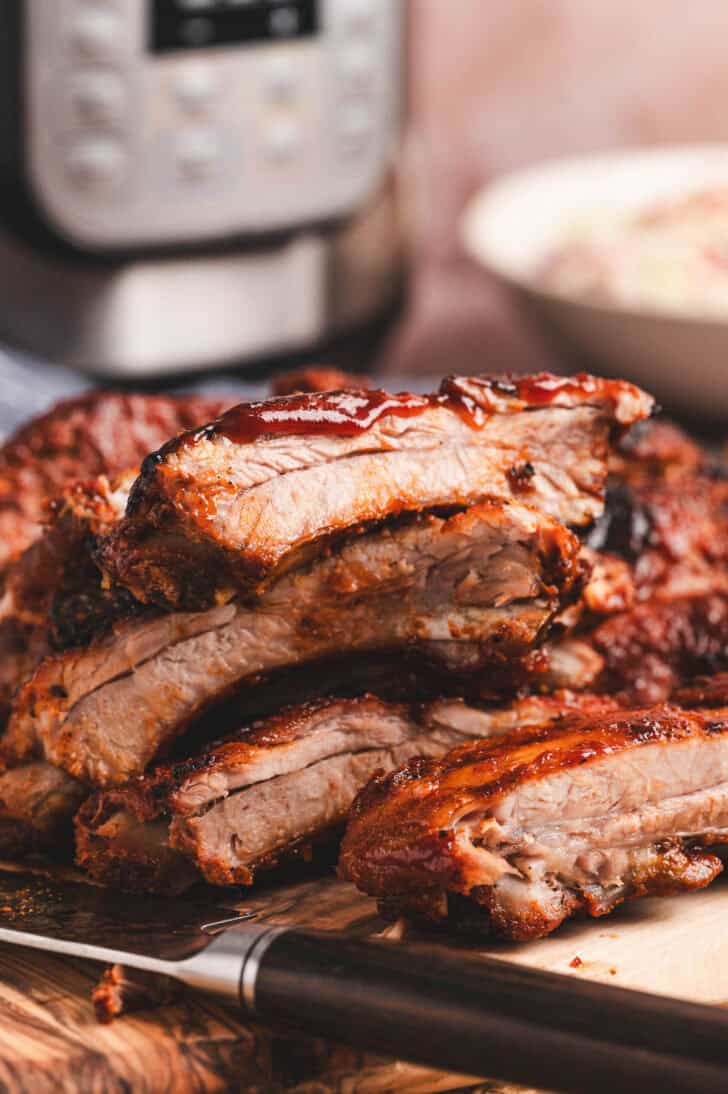 A pile of ribs in Instant Pot on a cutting board.