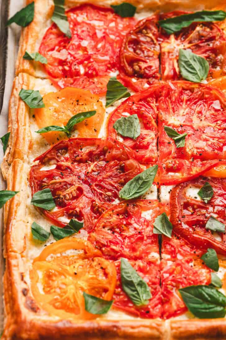 A tomato ricotta tart garnished with basil.