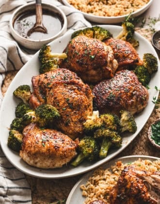 A serving platter filled with balsamic chicken thighs and broccoli.
