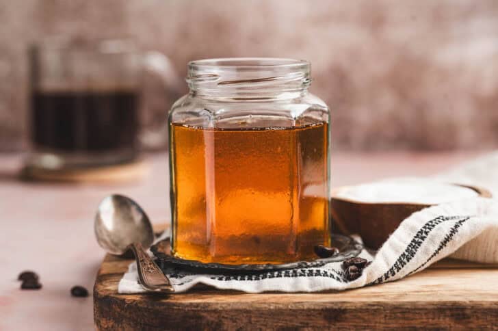 Caramel flavor syrup for coffee in a small glass jar.