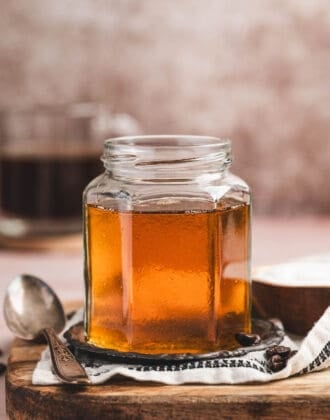 A glass jar of caramel syrup for coffee.