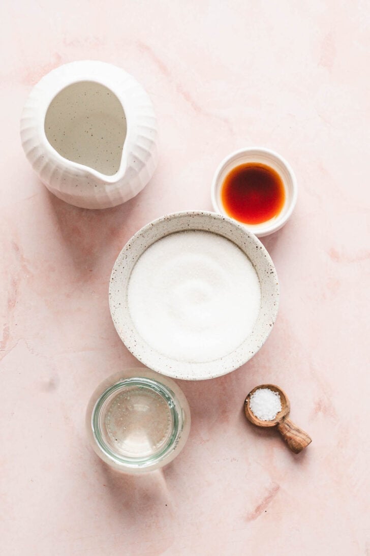 Sugar, cream, vanilla, salt and water on a light pink background.