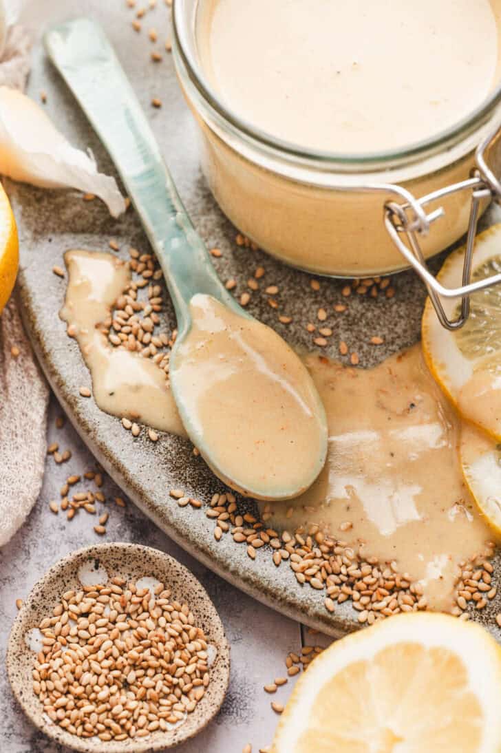 A spoon covered in lemon and tahini dressing.