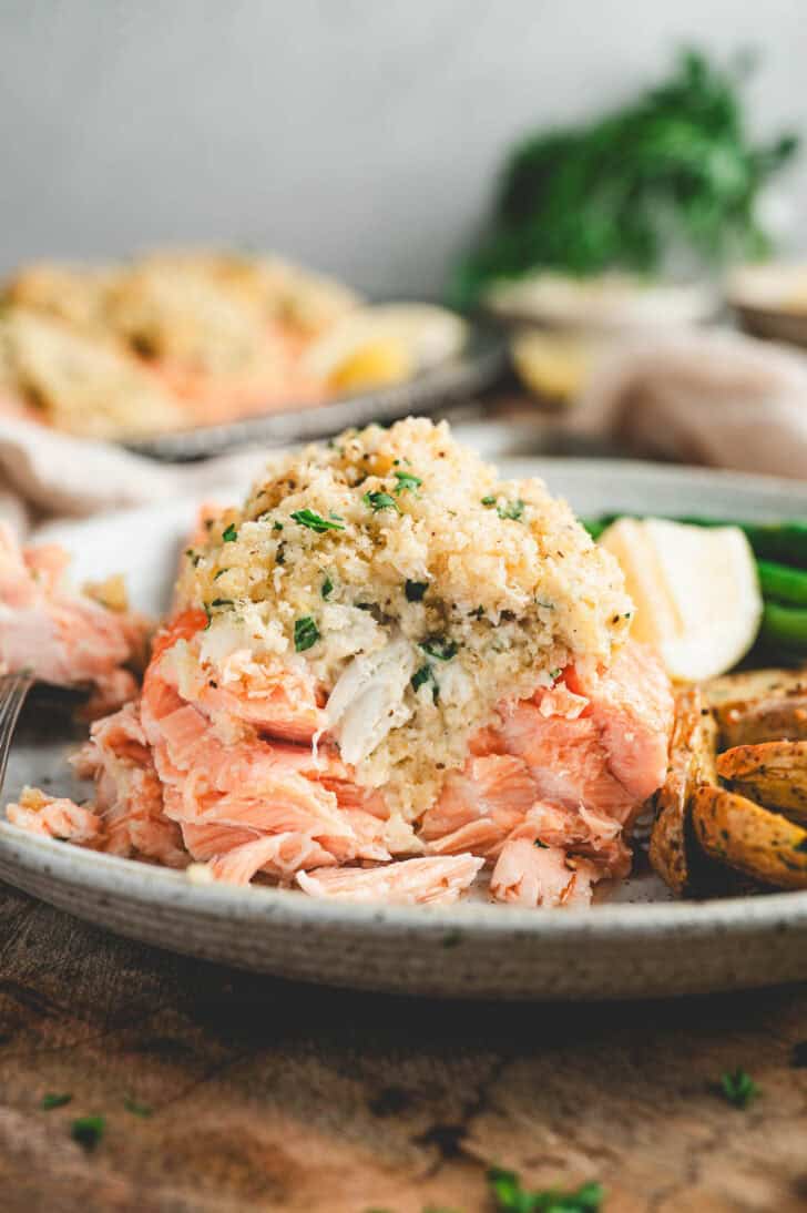A cross section of a crab stuffed salmon recipe on a plate.