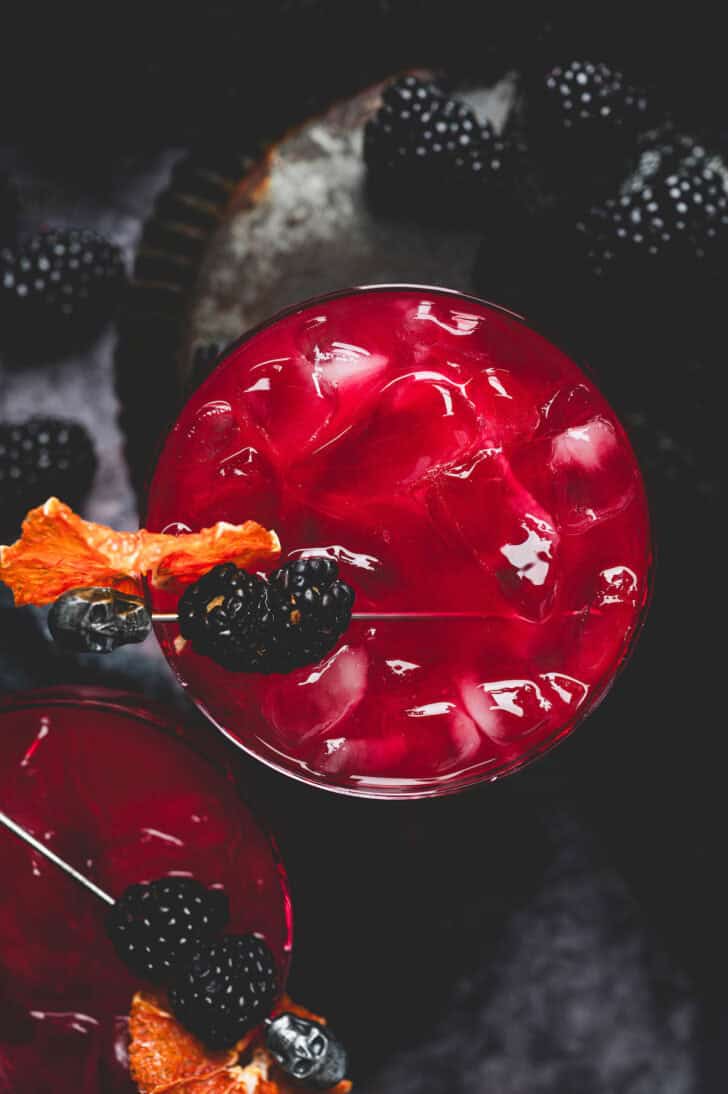 A deep red Halloween margarita on a dark surface.