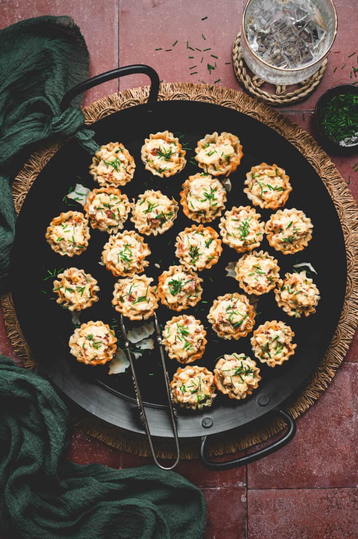 A dark serving platter filled with phyllo cups.