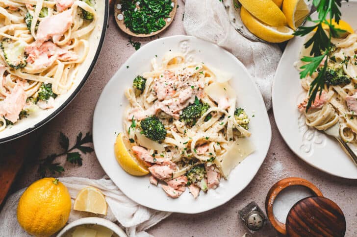 Salmon alfredo pasta on fancy white plates.