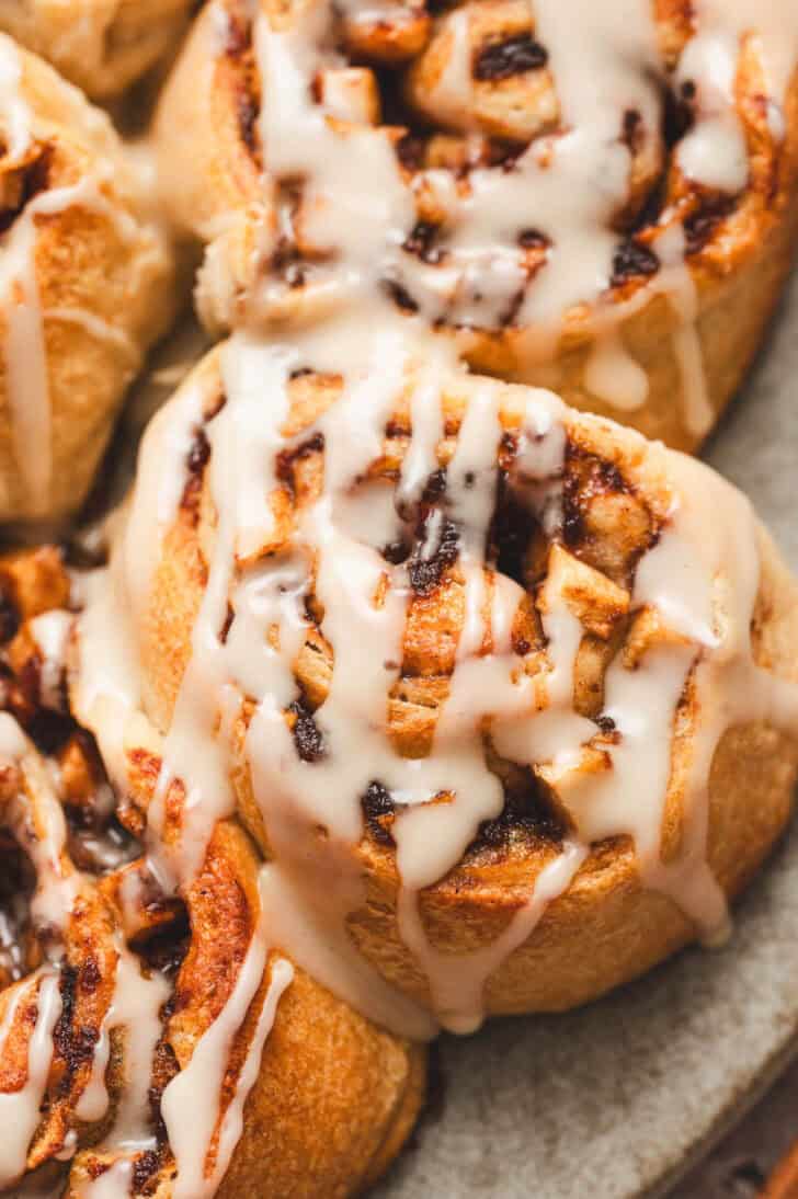 Closeup on crescent roll cinnamon rolls drizzled with icing.
