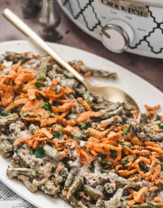 A white platter filled with crockpot green bean casserole.