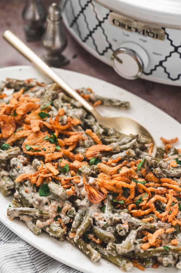 A white platter filled with crockpot green bean casserole.