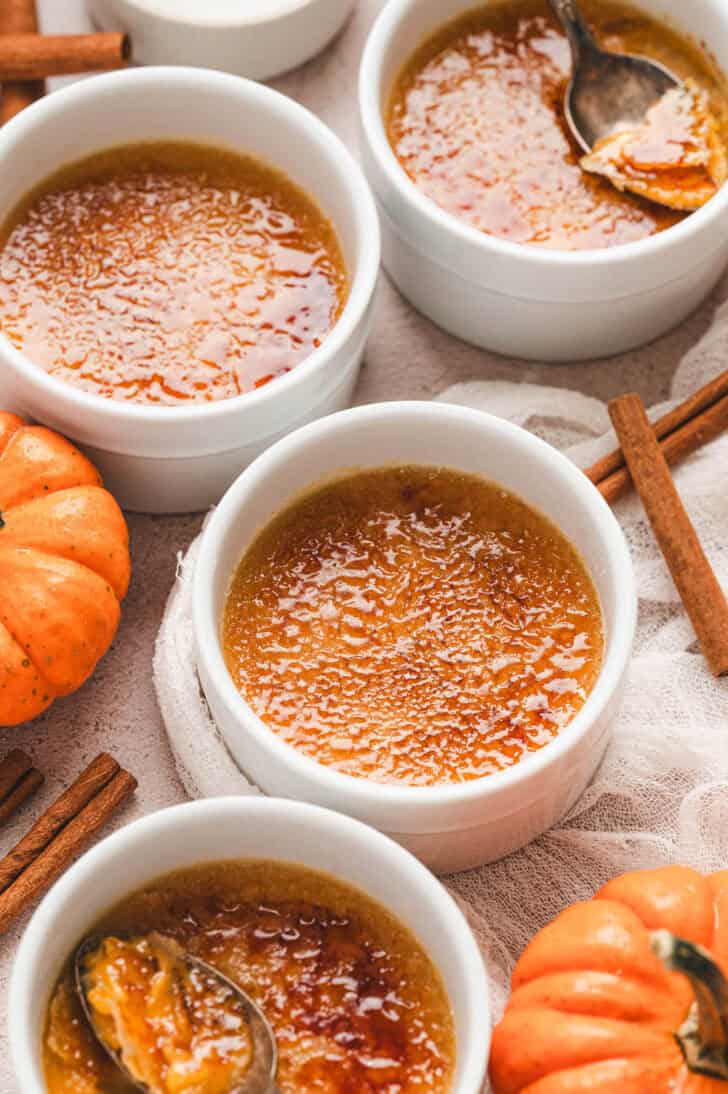 Four ramekins of pumpkin creme brulee.