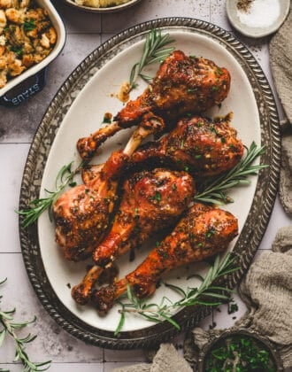 A large platter filled with five roasted turkey legs.